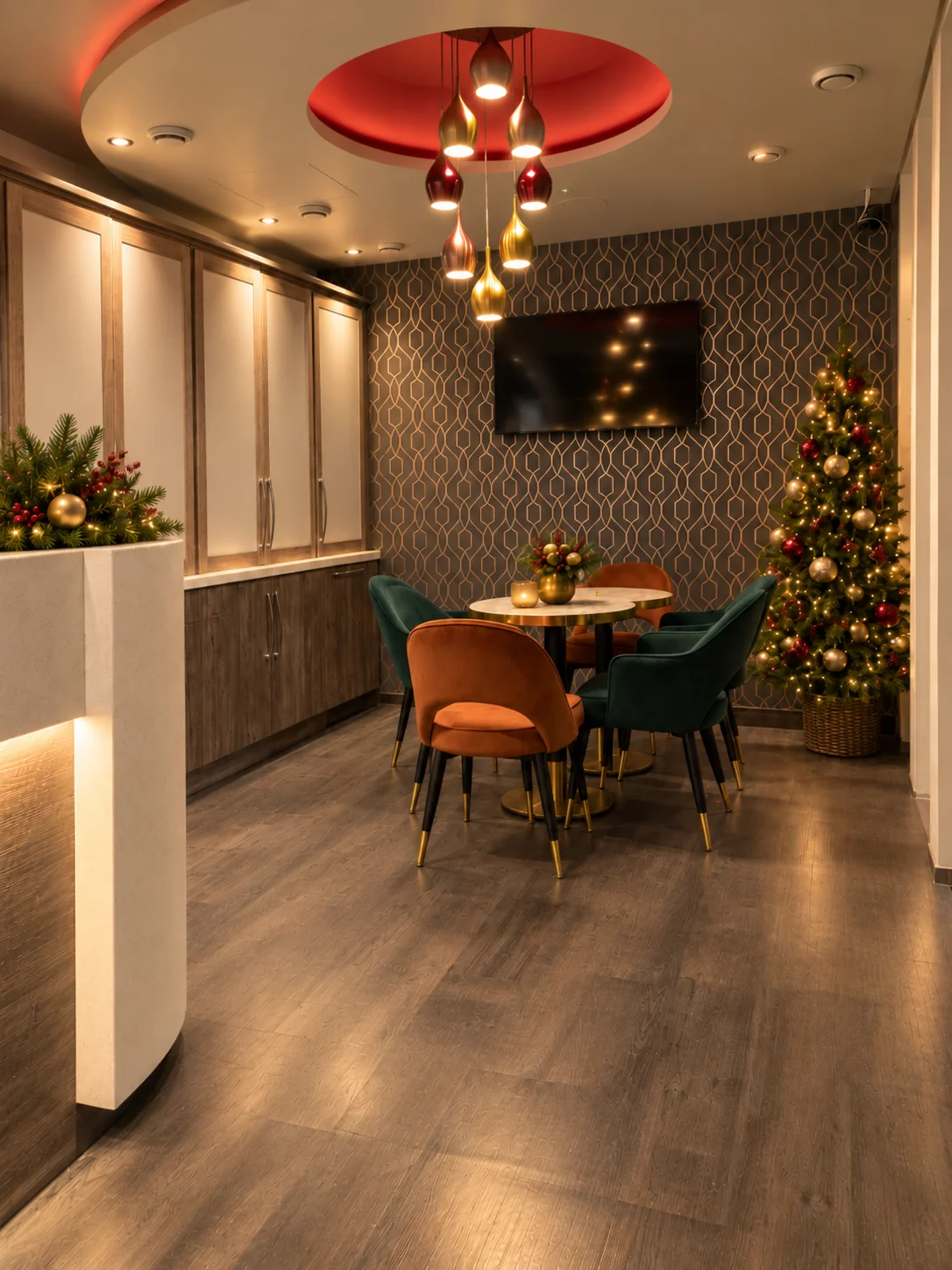 The lounge beside reception at London Court Hotel, with green and orange velvet chairs around a marble table, shown with a Christmas tree and festive lights